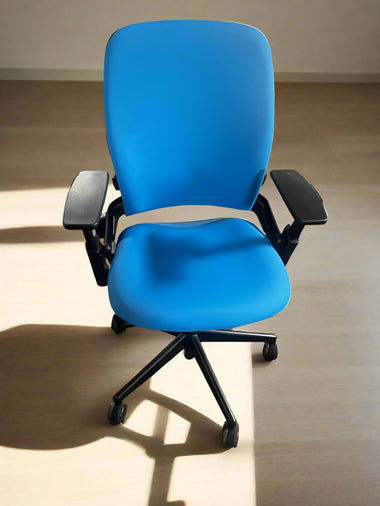 Blue office chair on a carpeted floor with a wooden cabinet in the background
